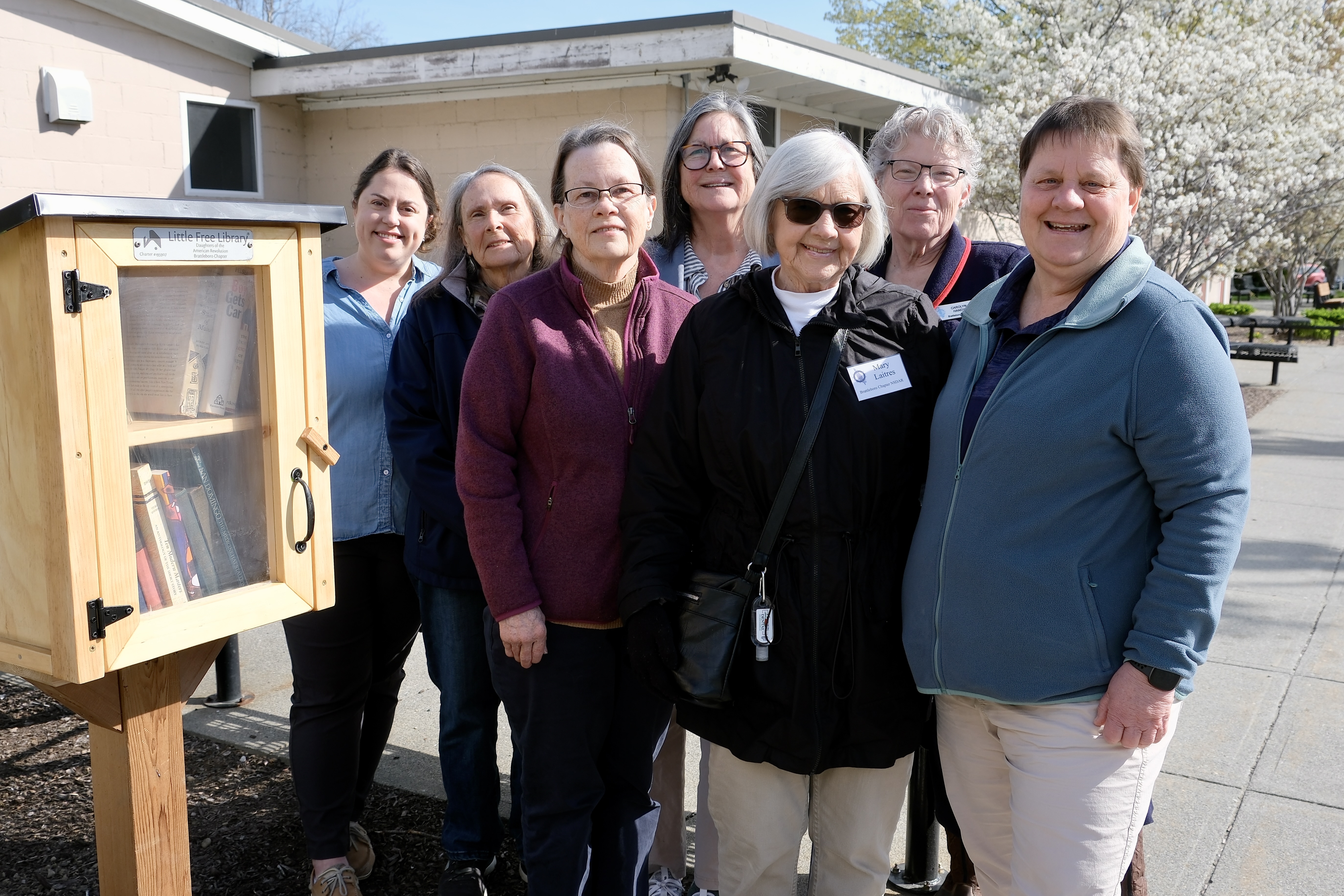 Members of the Brattleboro Chapter of the National Society of the Daughters of the American Revolution and Recreation and Parks Director Carol Lalotte pose beside the Little Free Library.